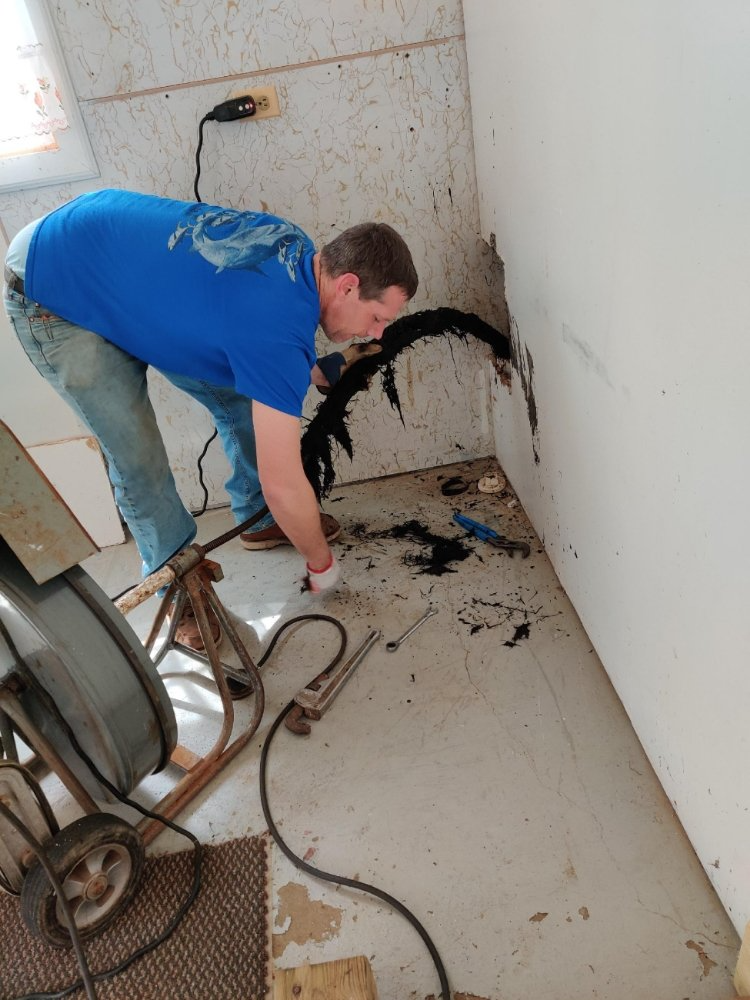 plumber pulling gunk out of a wall