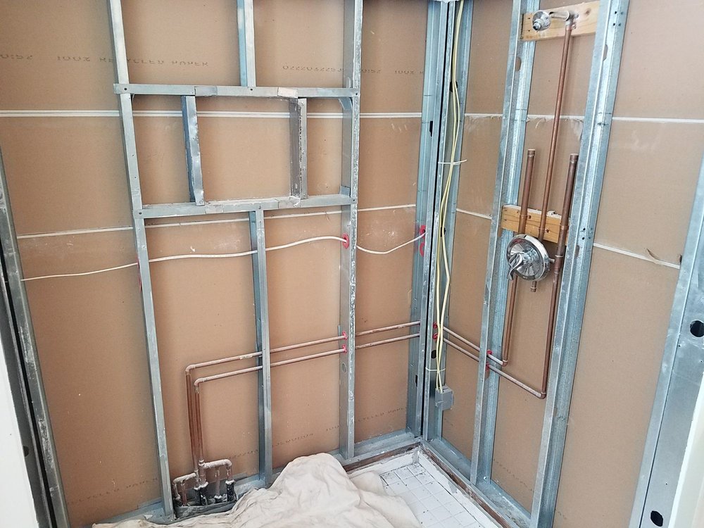 shower with no walls and exposed pipes