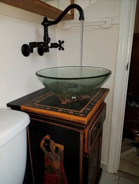 round glass sink with black faucet